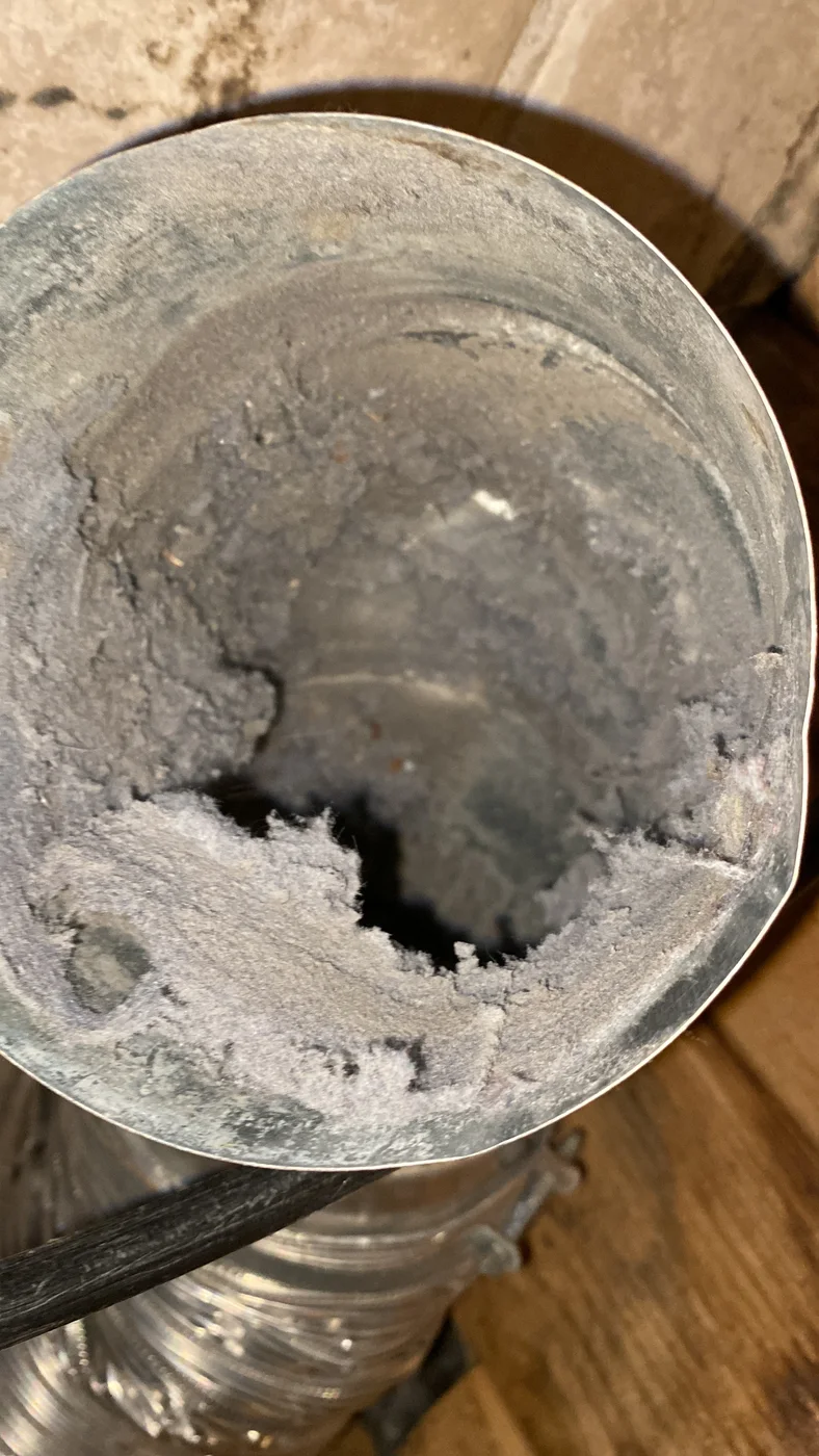 Heavy lint buildup inside a round metal dryer exhaust duct